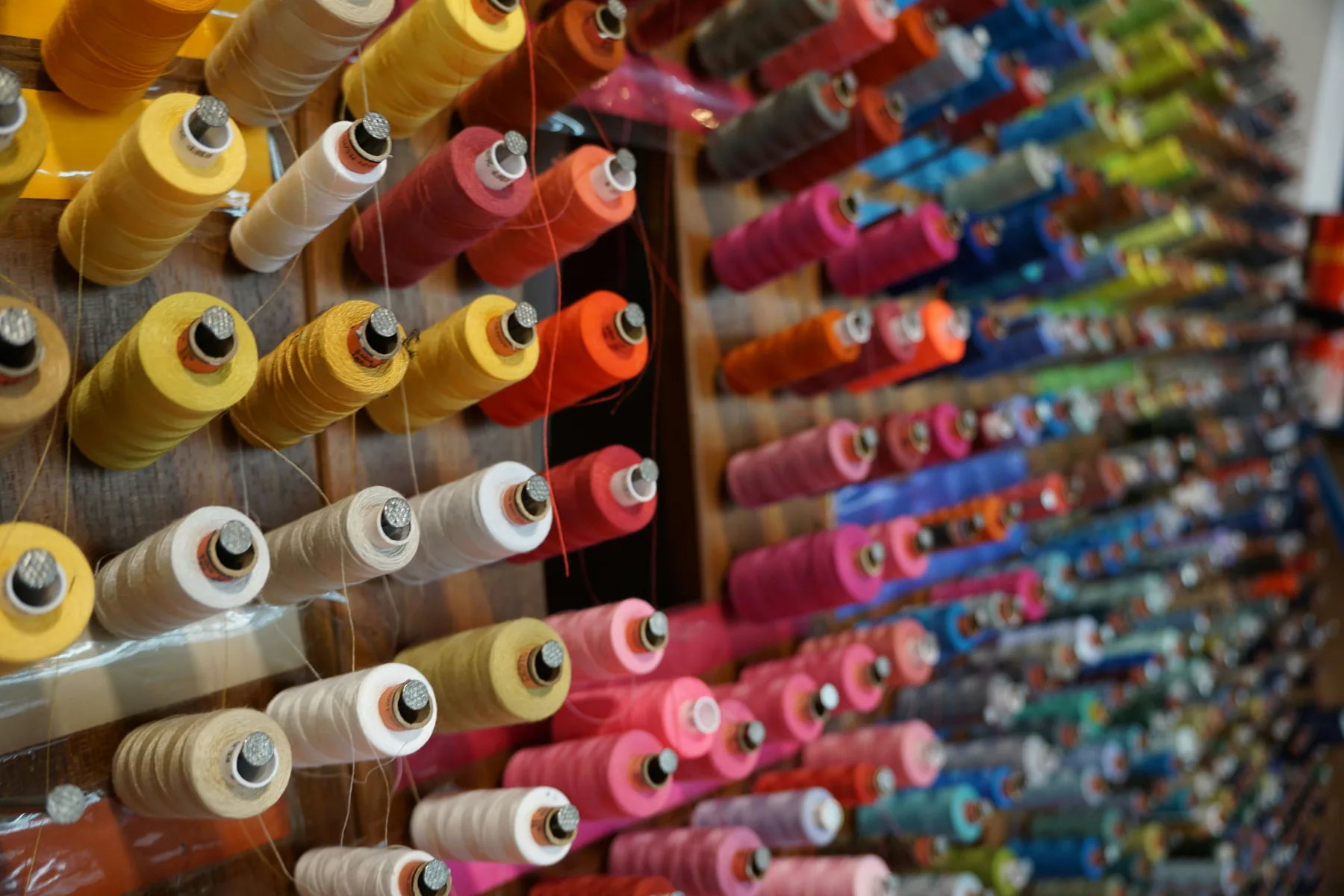 Colorful sewing thread displayed on a wall rack